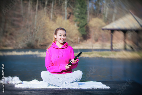 Sport teenage girl using tablet touchpad on pier © Voyagerix