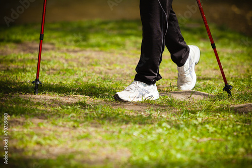 Nordic walking. Female legs hiking in the park. © Voyagerix