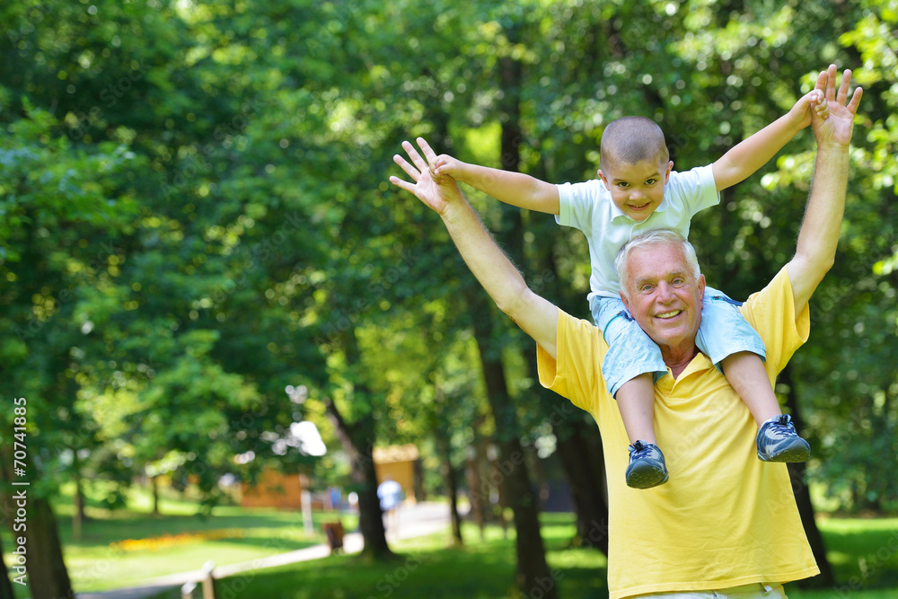 Obraz premium happy grandfather and child in park