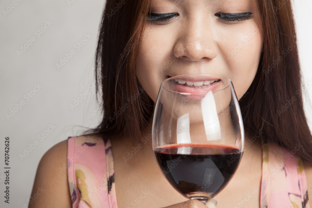 Beautiful Asian woman smell aroma of red wine and smile Beautiful Asian woman smell aroma of red wine and smile