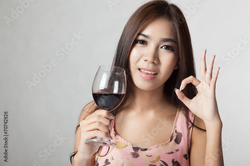 Beautiful Asian woman show OK sign hold glass of  red wine © halfbottle
