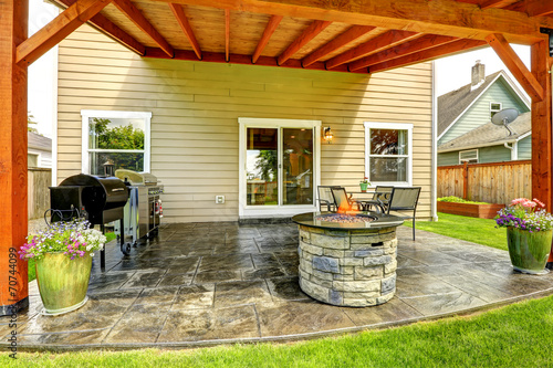 Patio area with tile floor and stone trimmed fire pit photo
