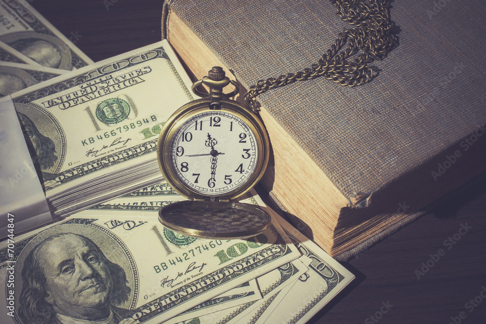 Pocket watch on bills and old book as vintage Pocket watch on bills and old book as vintage