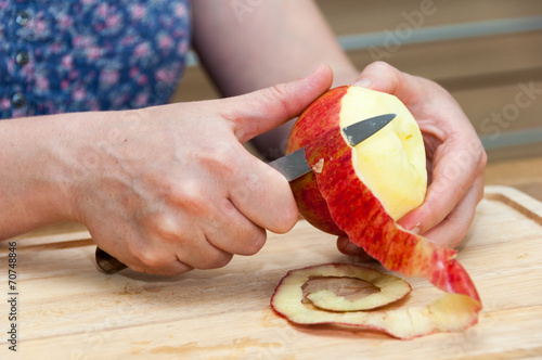 Hands peeling apple