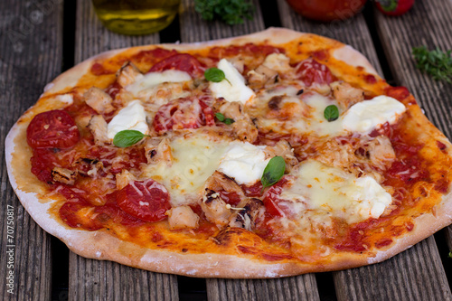 Homemade pizza with tomato sauce, tomatoes and mozzarella