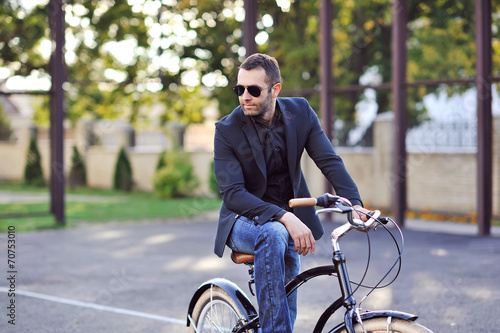 Businessman on his retro bike. Outdoor fashion portrait