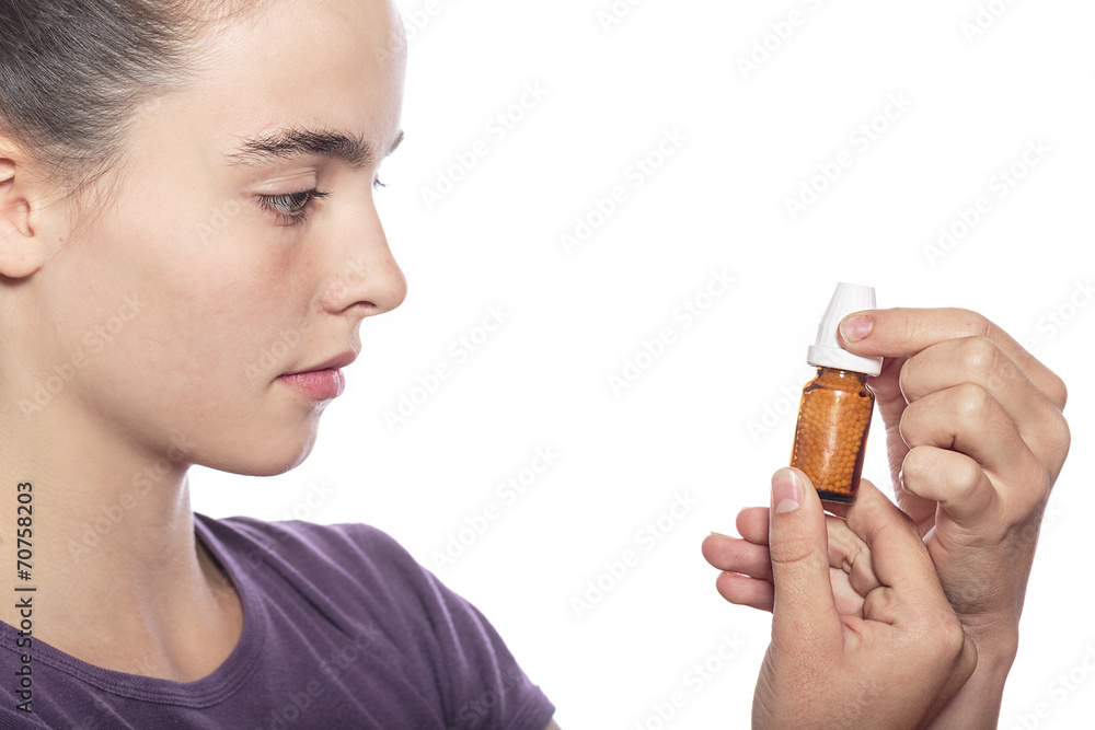 Fototapeta premium woman is examine a bottle of homeopathic medicine, isolated on w