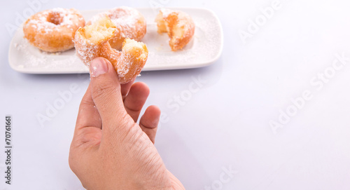 Female hand holding doughnuts over white background
