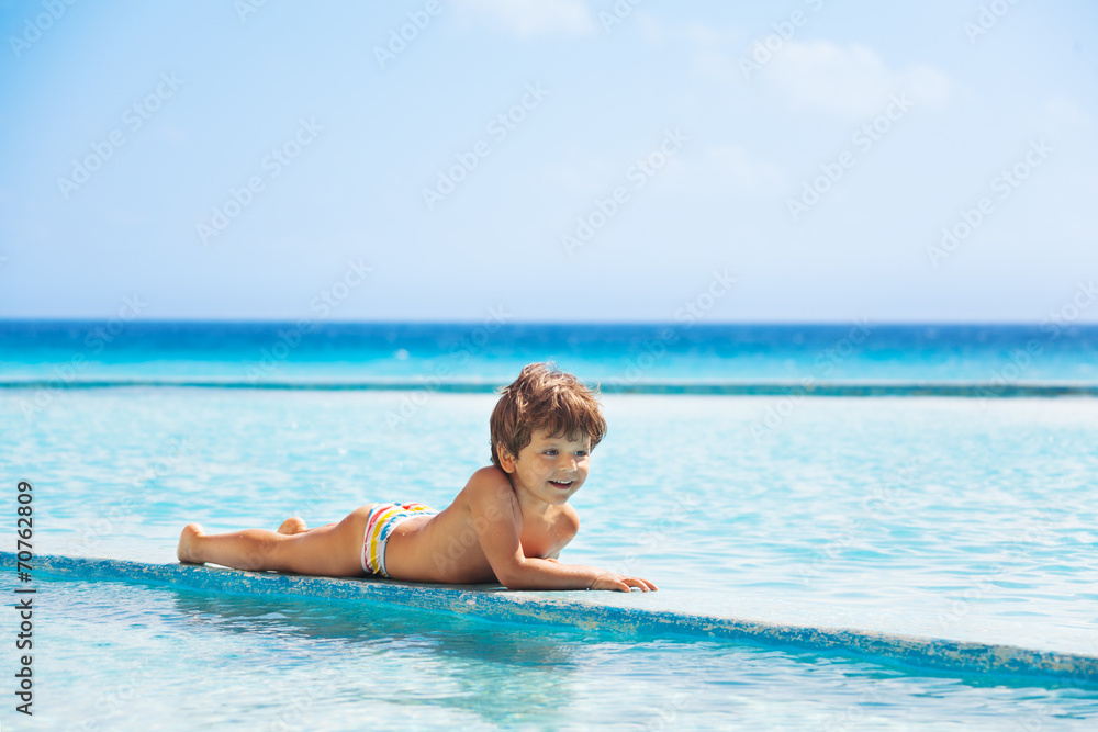 Happy boy laying on boarder of swimming pool Happy boy laying on boarder of swimming pool