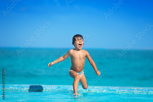 Excited kid in slow motion of jumping into  water