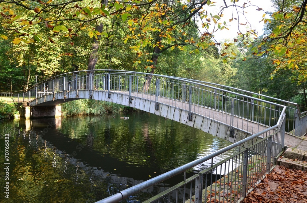 Rundbogenbrücke im Park herbstlich