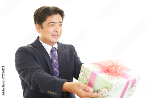 プレゼントを持つ笑顔のビジネスマン