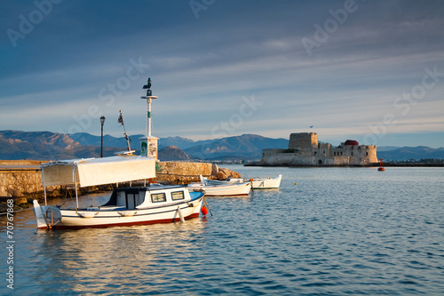Fishing boats in Nafplio harbour and Bourtzi castle, Greece.