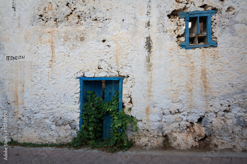 Traditional house in Crete with a sign 'for sale', Greece. © milangonda