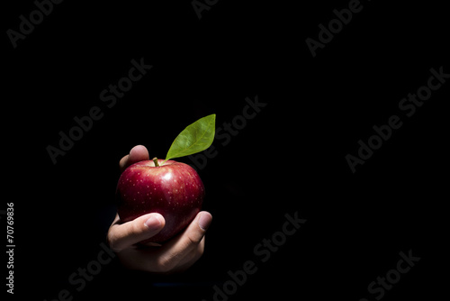 Hand offering an apple.