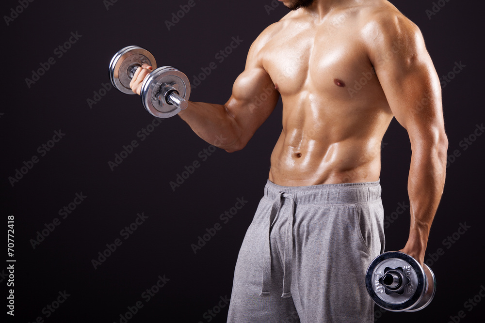 Fitness man lifting dumbbells on black background