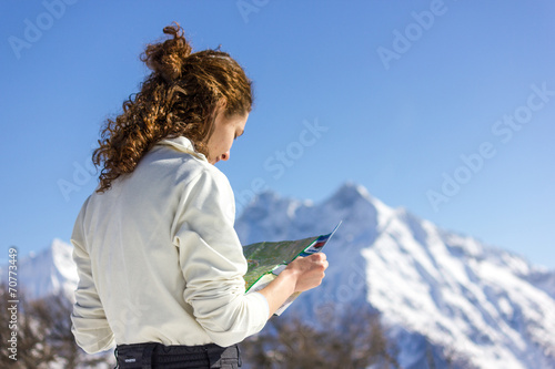 Ragazza guarda mappa con paesaggio invernale