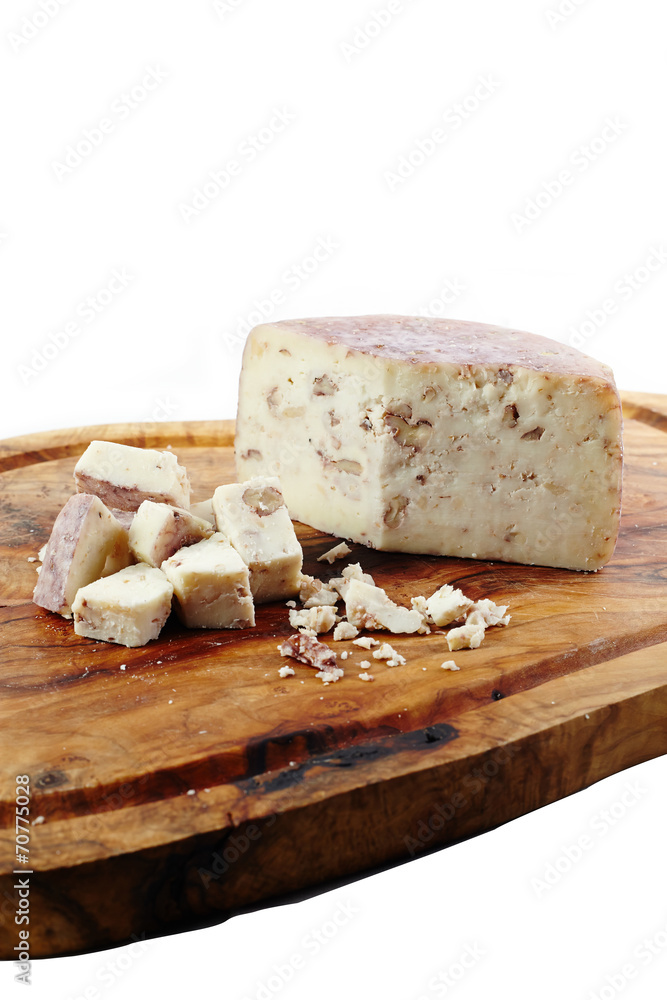 Cheese with nuts on wooden board and white background