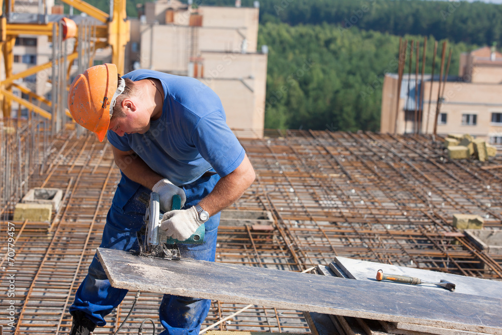 Carpenter worker cutting wood sheet with handheld circular saw Carpenter worker cutting wood sheet with handheld circular saw