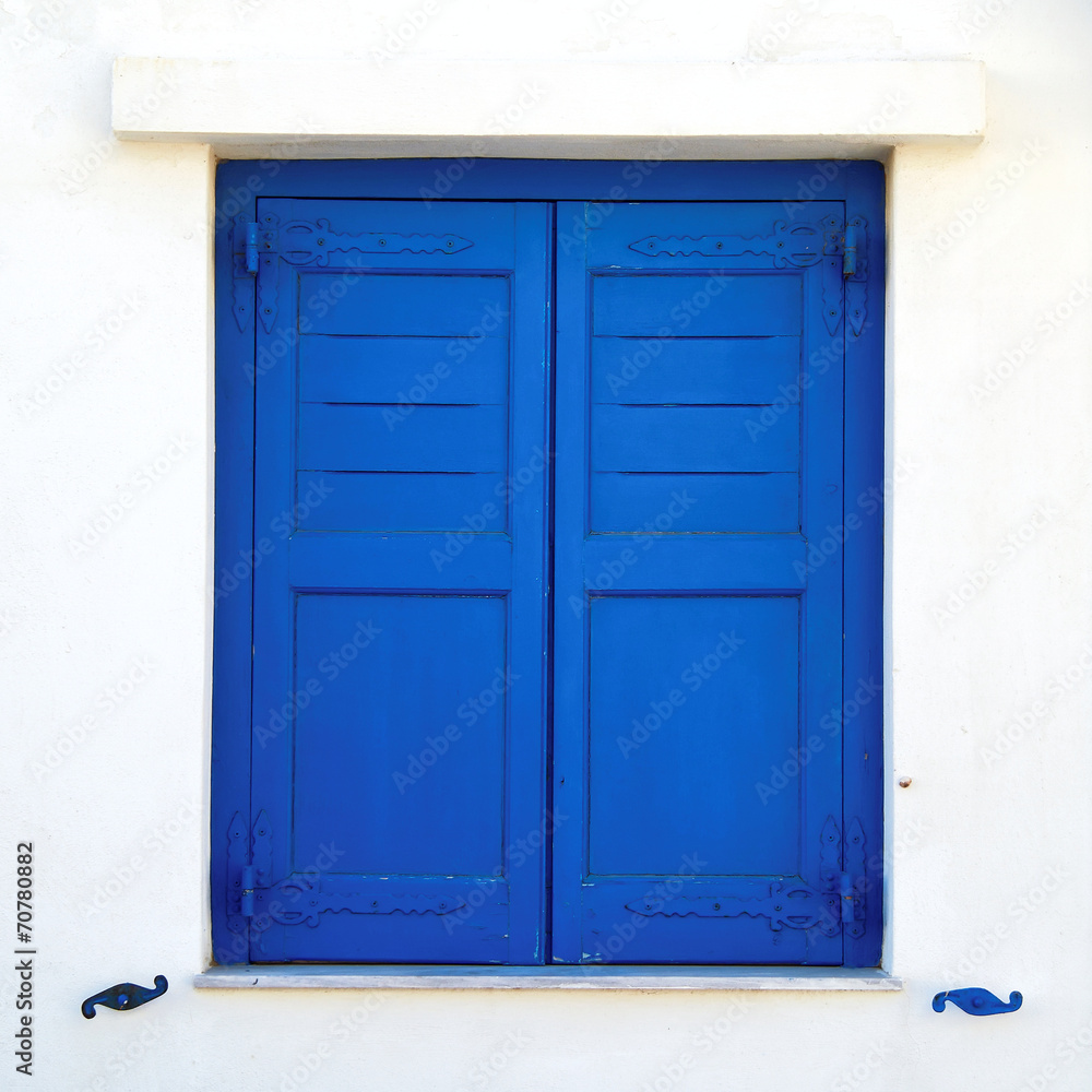 Greece, blue painted window shutters on white wall