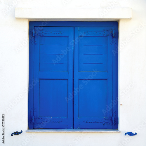 Greece, blue painted window shutters on white wall