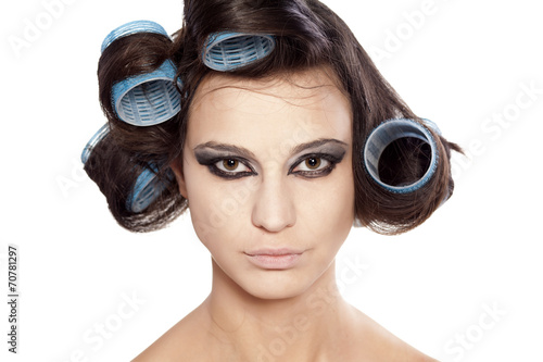 Funny woman with curlers and uncompleted bad makeup