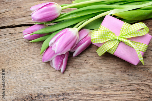 Tulips with a gift box on old wooden