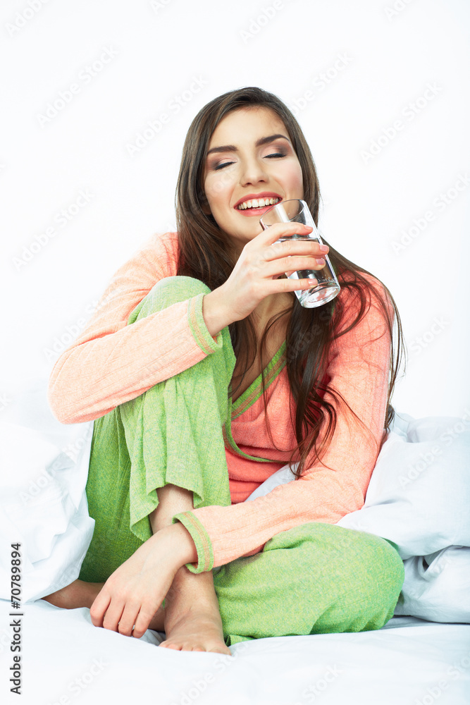 Smiling woman closed eyes in bed hold water glass.