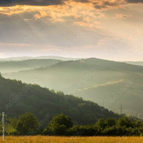cold fog on hot sunrise in mountains