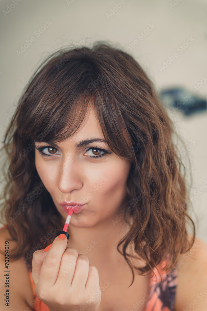 Young woman applying her lipstick Young woman applying her lipstick
