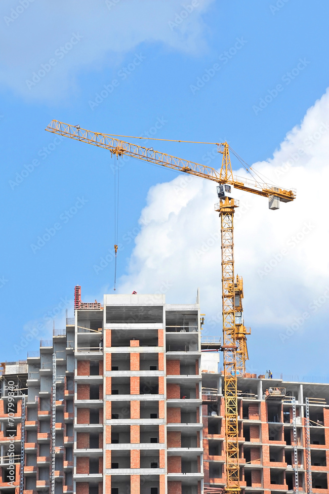 Crane and building construction site against blue sky Crane and building construction site against blue sky