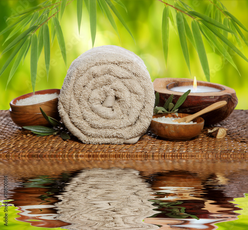 Spa background with rolled towel, bamboo and candlelight