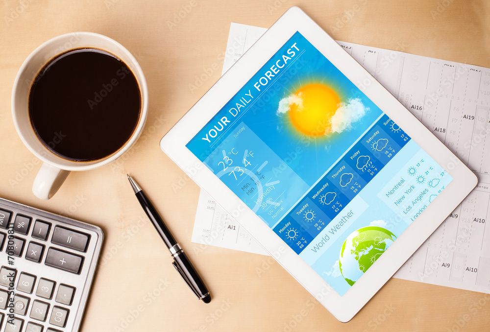 Tablet pc showing weather forecast on screen with a cup of coffe - obrazy, fototapety, plakaty 