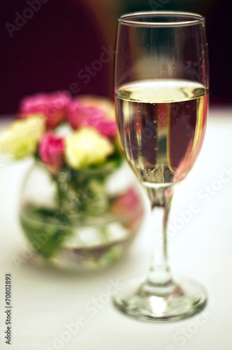 Bouquet of roses and glass of champagne