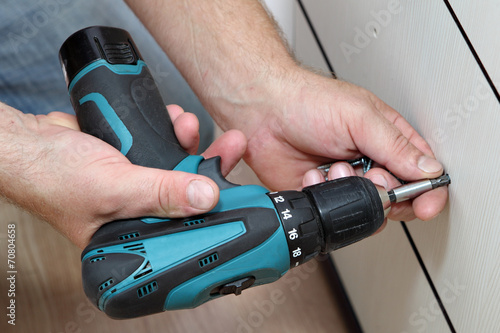Obraz na płótnie Using cordless screwdriver for screwing screws when assembling f