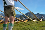 Alphornspieler mit Tracht im Gebirge
