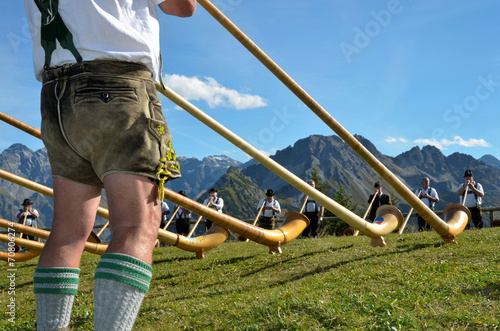 Alphornspieler mit Tracht im Gebirge photo