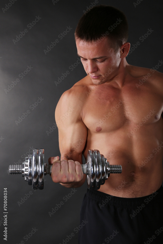 Handsome young muscular sportsman execute exercise with