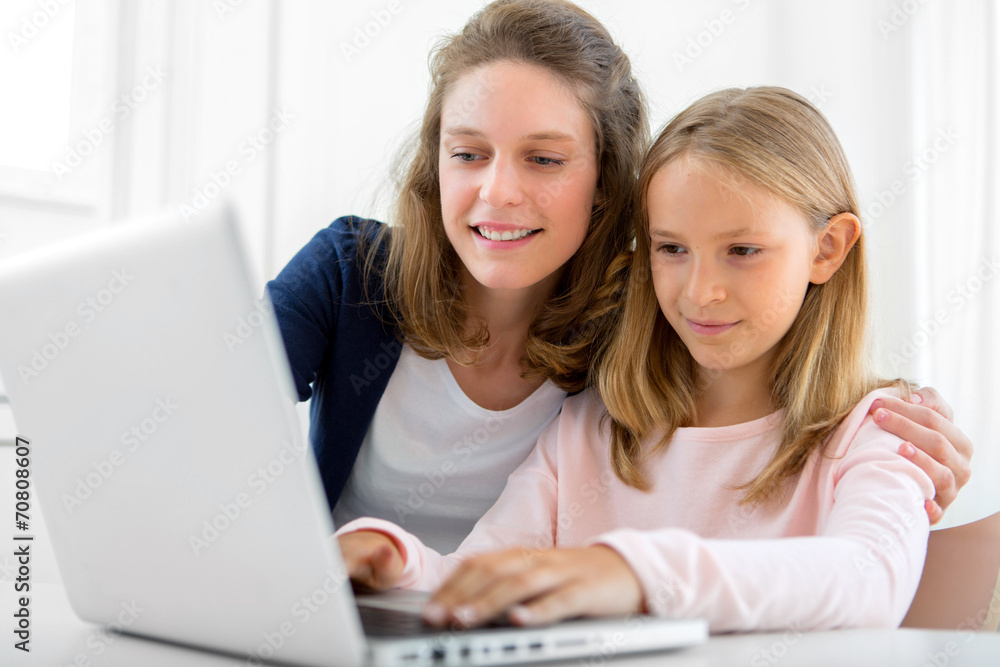 Attractive woman and little sister using laptop Attractive woman and little sister using laptop