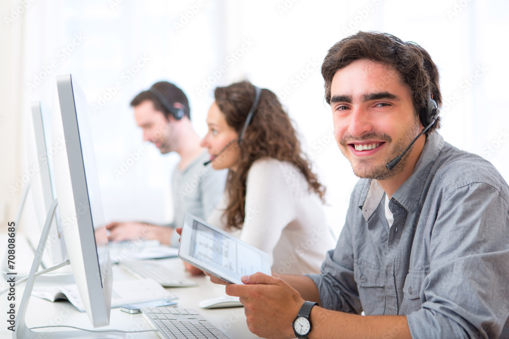 Young attractive man working in a call center