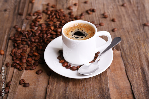 Cup of coffee and coffee beans on wooden background © Africa Studio