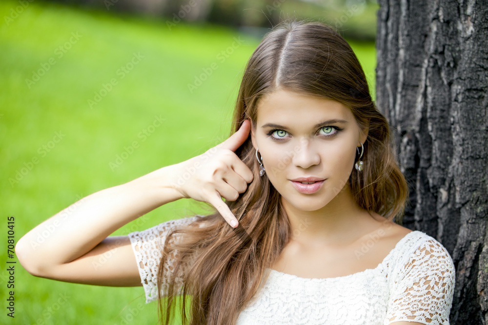 Beautiful woman making a call me gesture Beautiful woman making a call me gesture