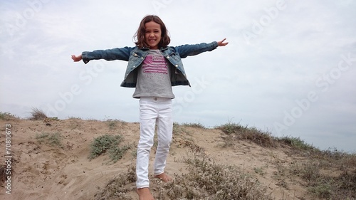 Niña descalza sobre duna de playa