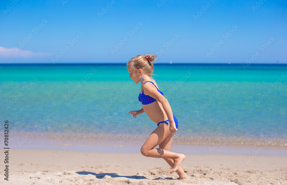 Adorable little girl making wheel on tropical white sandy beach