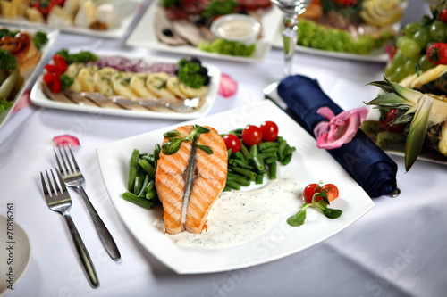 Grilled salmon steak with green beans, on decorated dining table