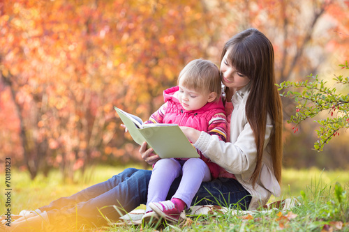 mother reading a book to ki...