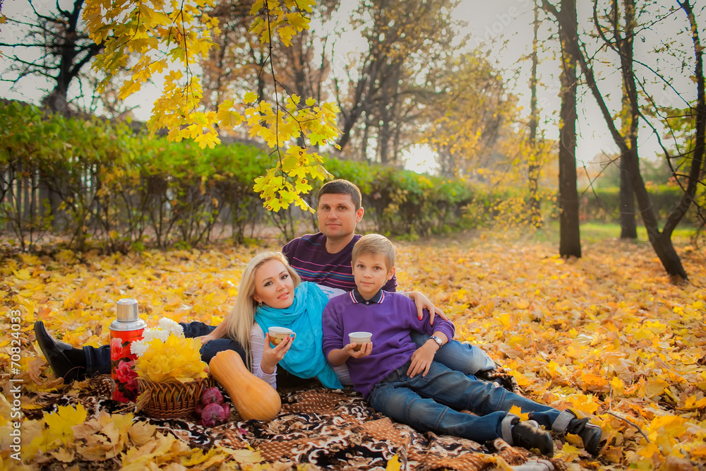wonderful parents and son in an autumn garden. yellow autumn lea wonderful parents and son in an autumn garden. yellow autumn lea