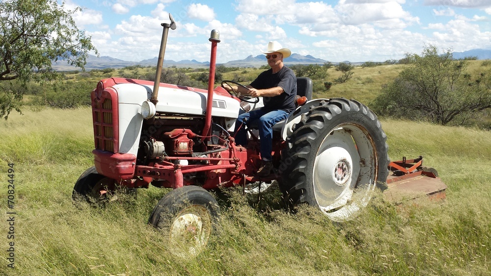 Obraz premium Mowing Arizona grasslands with the old tractor and brushhog