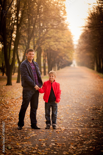 father and son walking in the autumn park