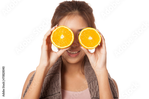 Asian healthy workout girl put orange over her eyes